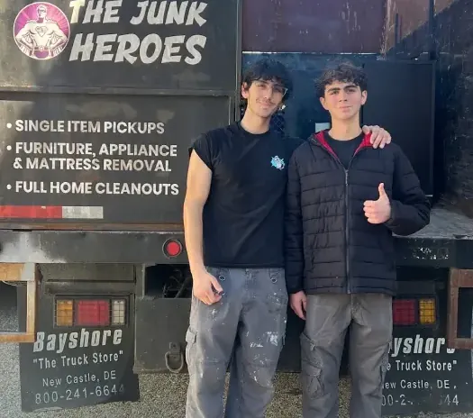 Henrique and Filipe standing in front of the branded Junk Heroes truck